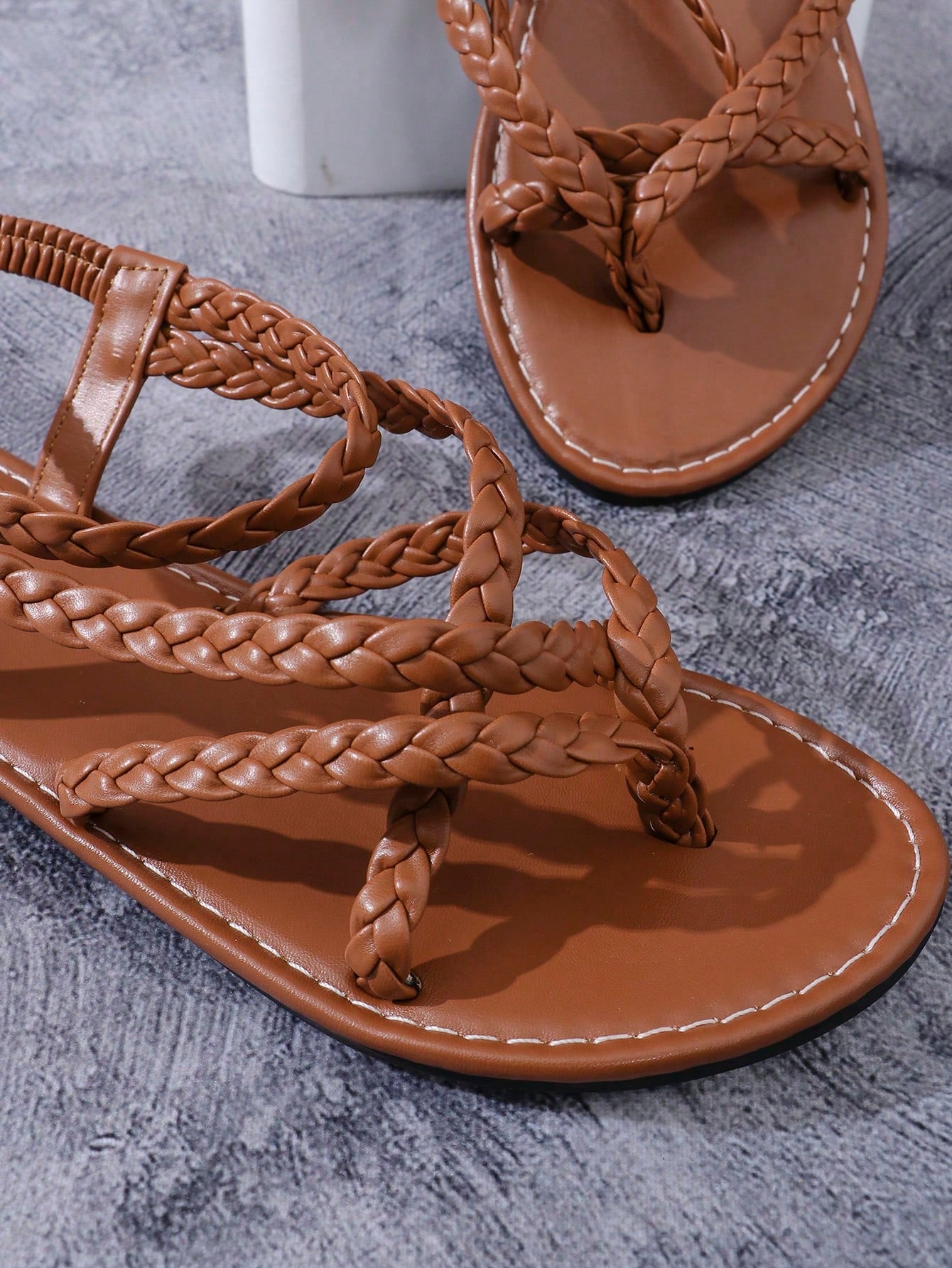 Women's woven criss-cross elastic flat sandals with braided strappy upper and toe post design