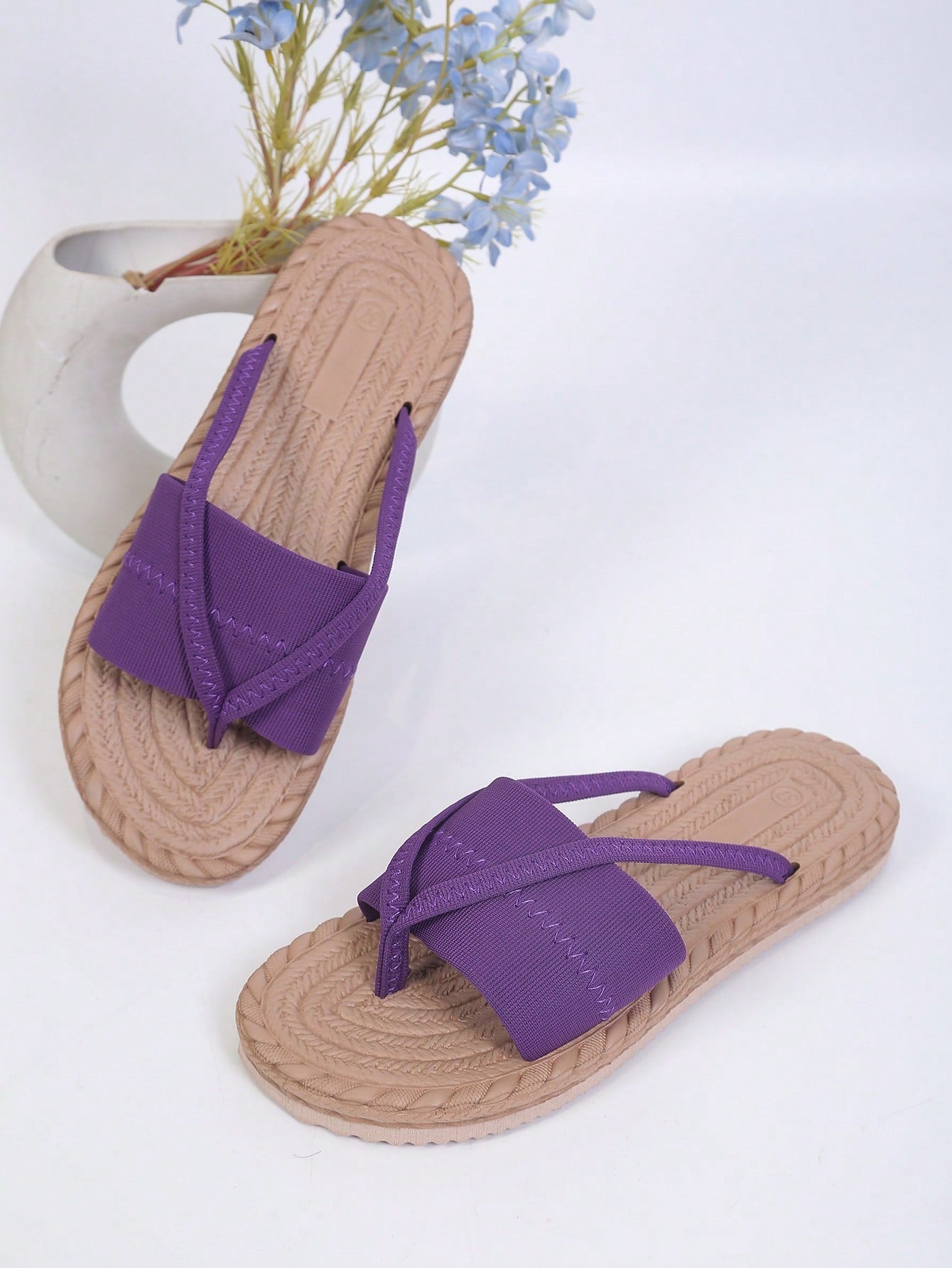Women's open-toe flat beach sandals with toe ring strap and bow decoration, lightweight slip-on style for vacation and outdoor use.