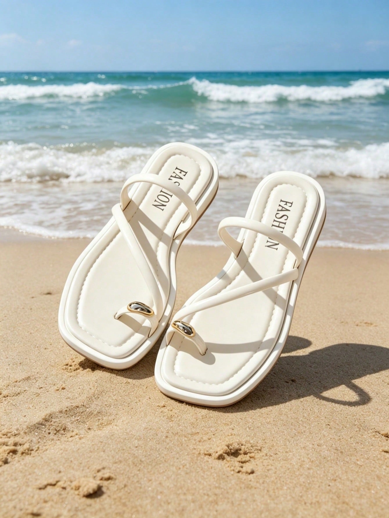 Women's white flat slide sandals featuring criss cross straps, shell detail, and buckle accents