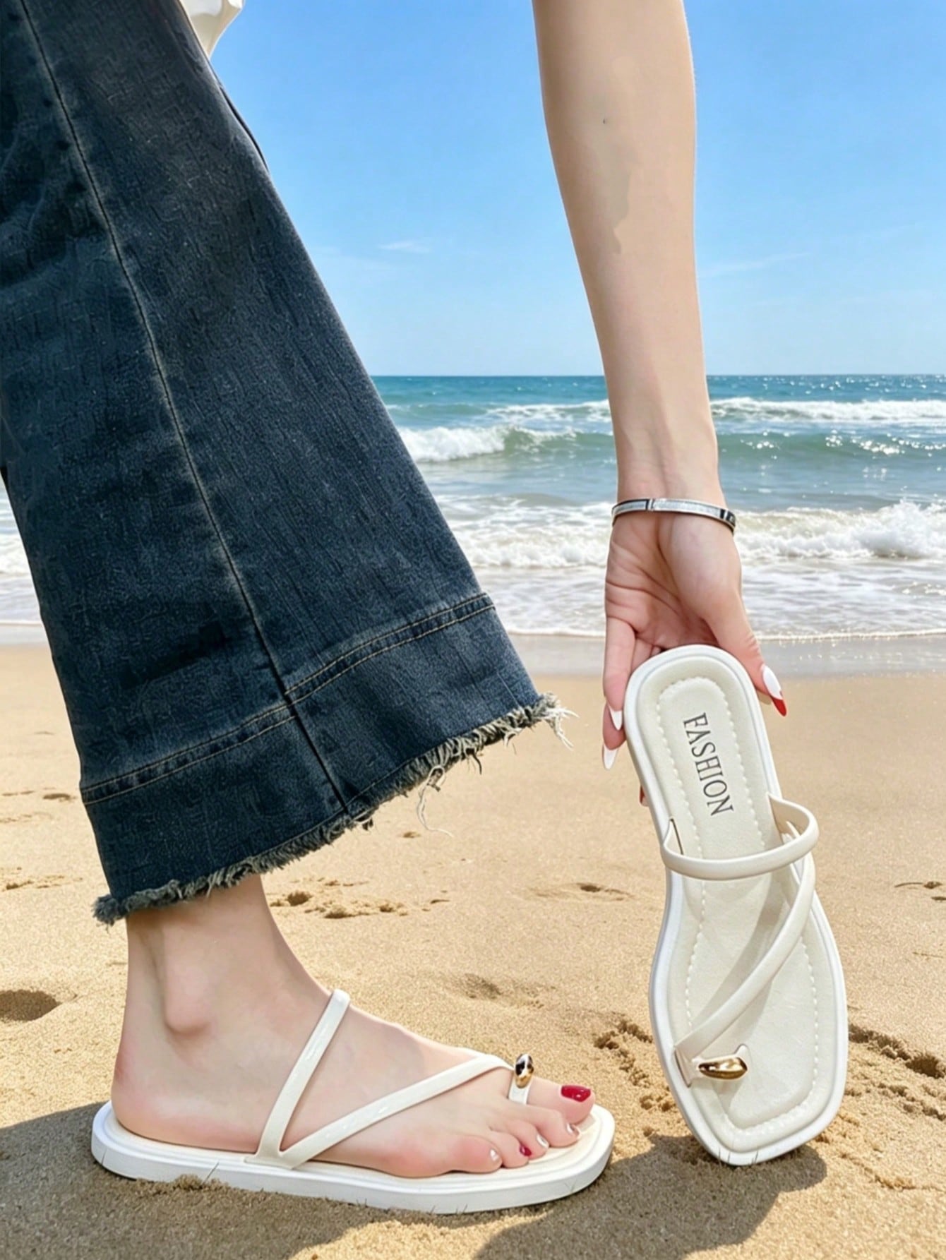Women's white flat slide sandals featuring criss cross straps, shell detail, and buckle accents