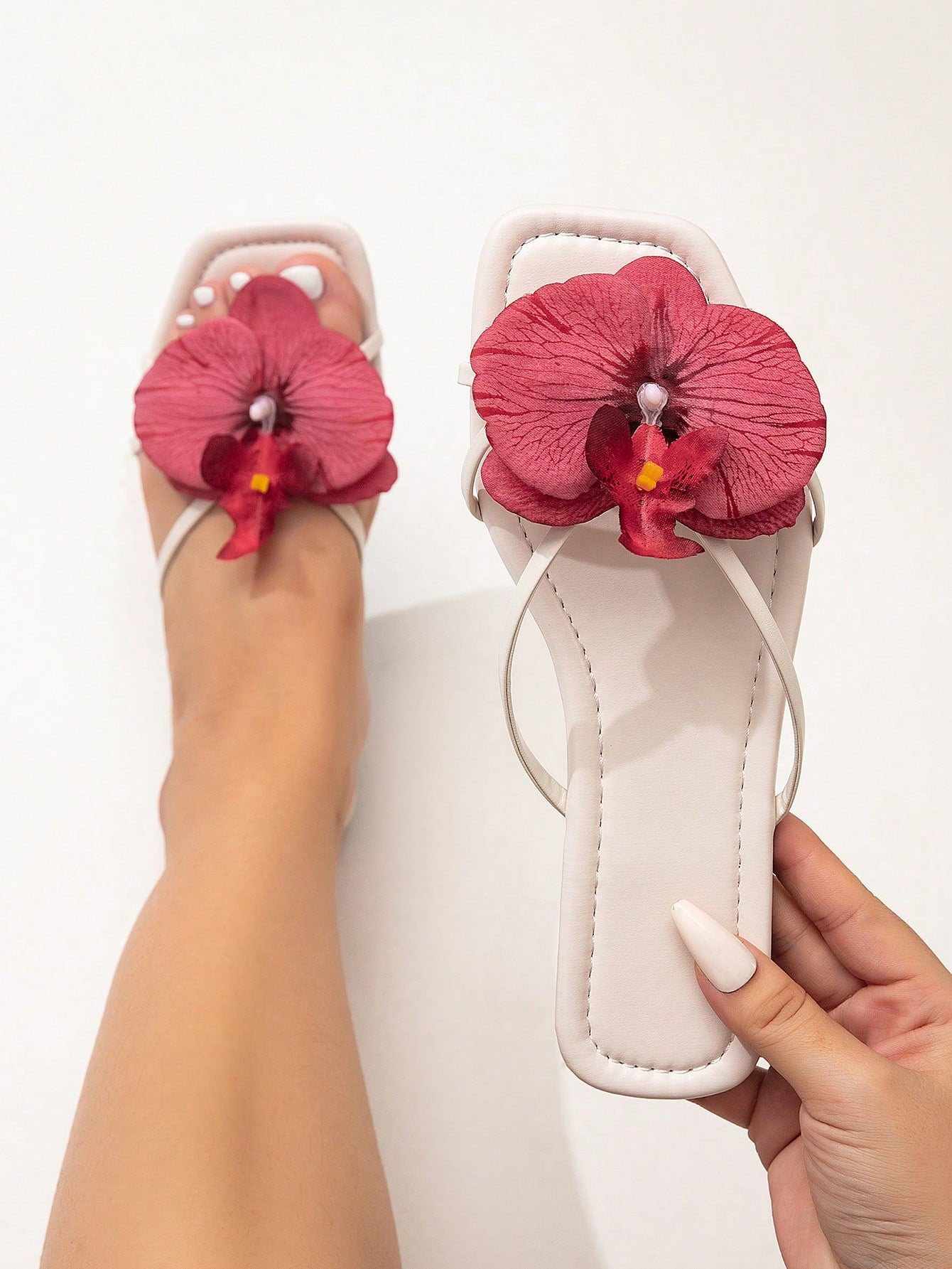 Wide fit women's beige flat thong sandals with butterfly orchid appliqué decor and open toe, suitable for beach, vacation, home, and casual everyday wear.