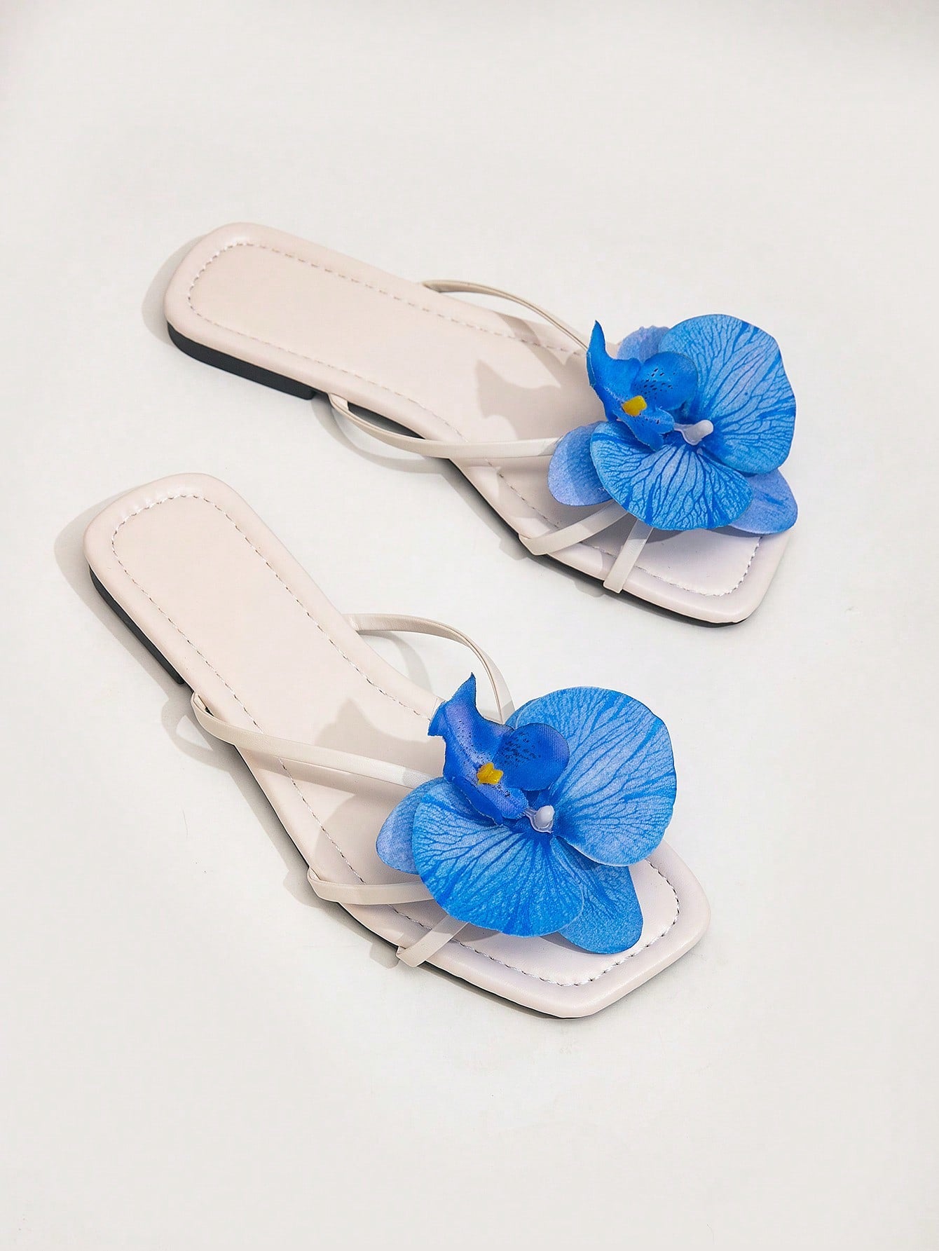 Wide fit women's beige flat thong sandals with butterfly orchid appliqué decor and open toe, suitable for beach, vacation, home, and casual everyday wear.