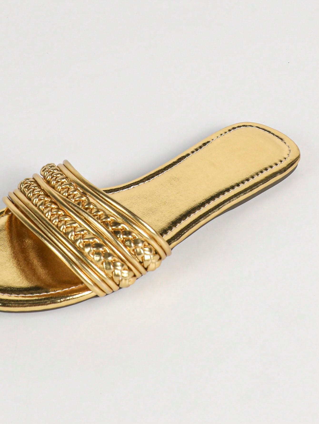 Women's gold flat sandals with metal accent detail, strappy lace-up design, and toe post thong style.