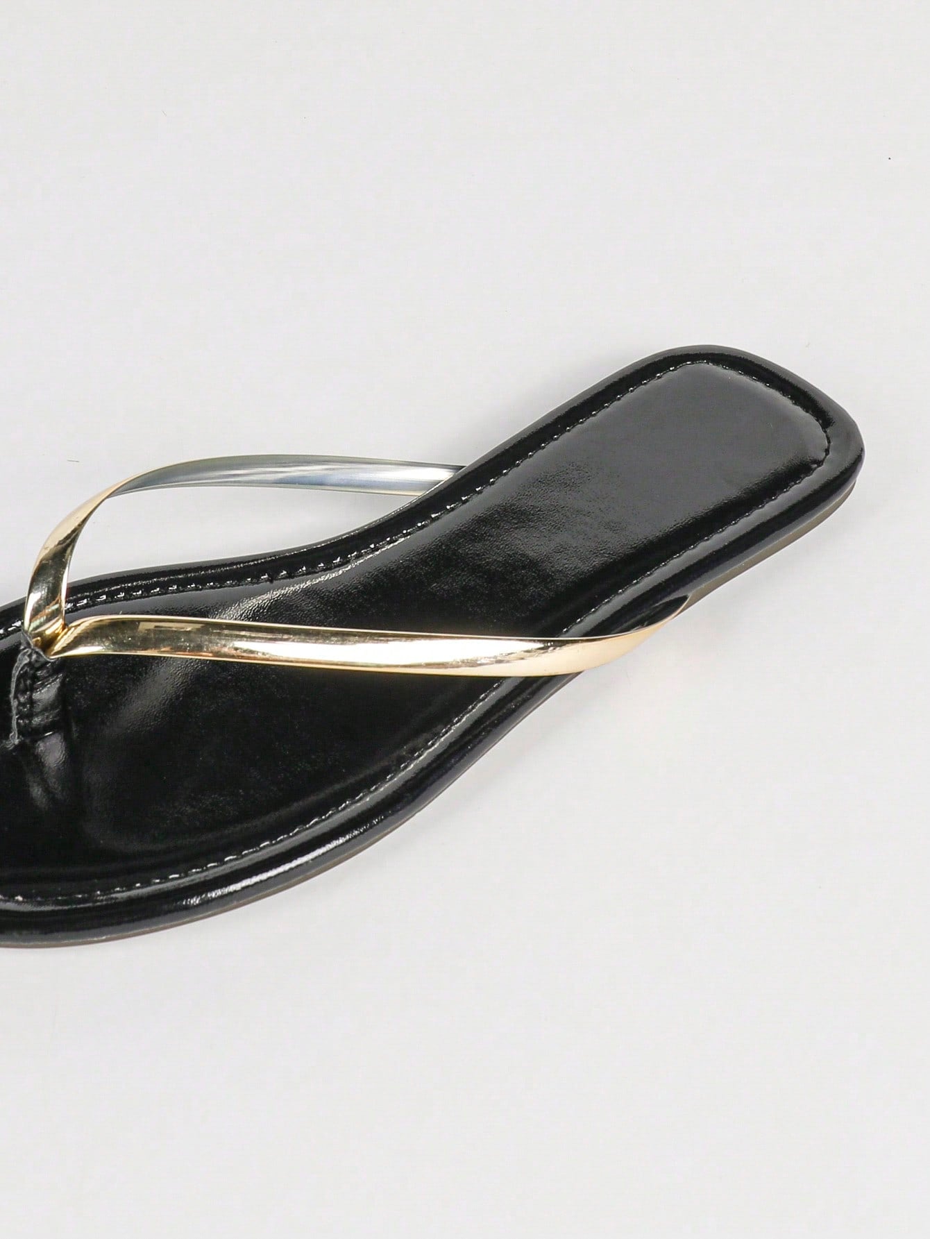 Women's gold flat sandals with metal accent detail, strappy lace-up design, and toe post thong style.
