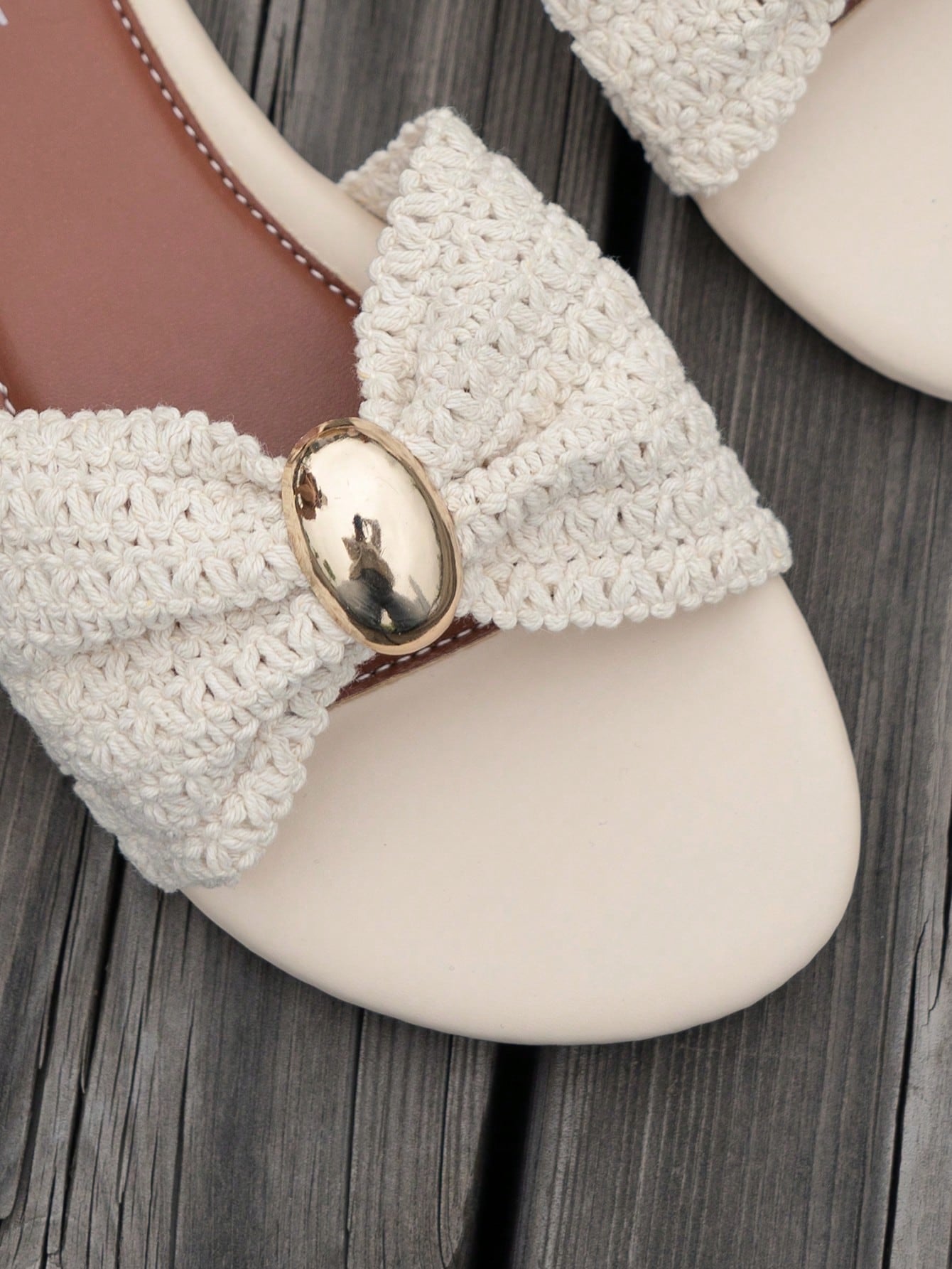 Women's brown straw woven flat slide sandals with bowknot metal decor, braided open-toe strap, and round toe.