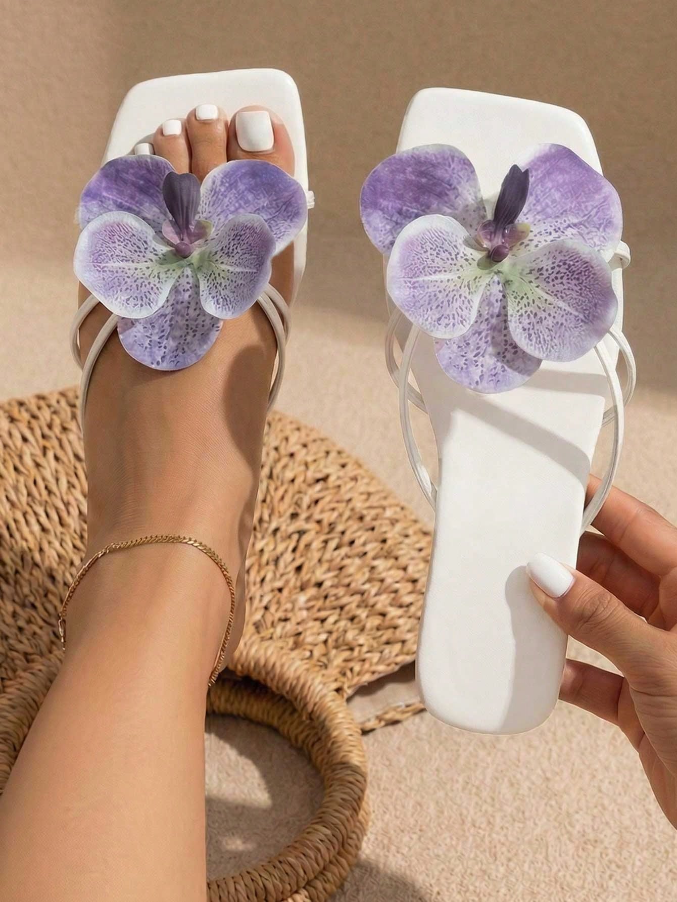 Women's black flat slide sandals with toe post design, textured PU leather straps, and rhinestone heart decoration.