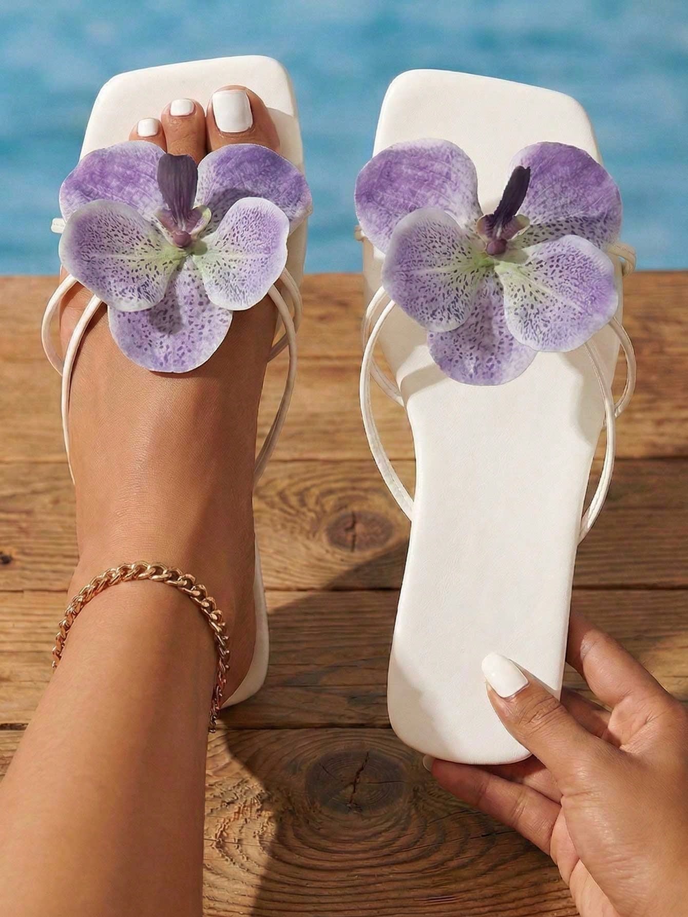 Women's black flat slide sandals with toe post design, textured PU leather straps, and rhinestone heart decoration.