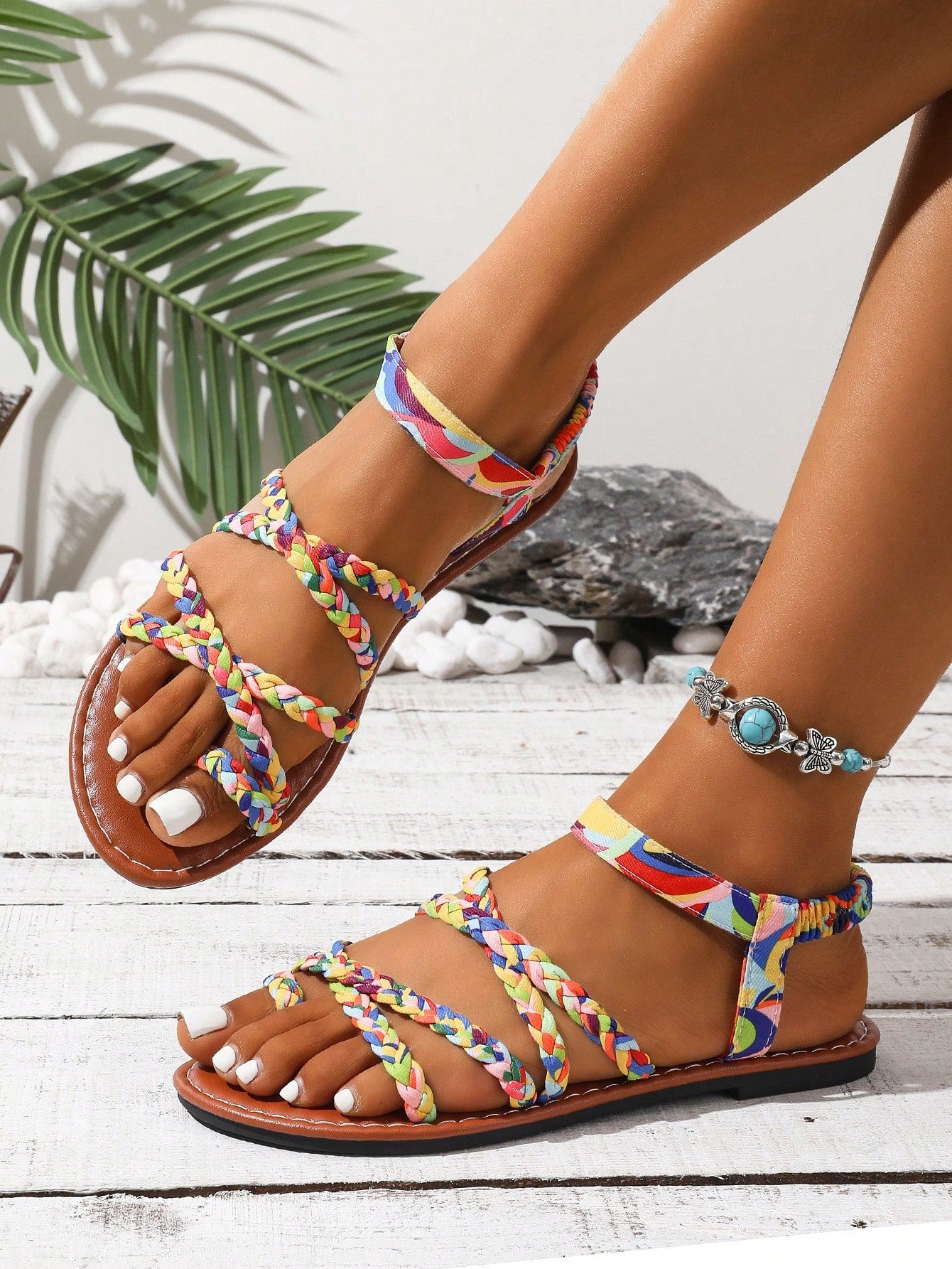 Women's flat sandals featuring a solid-color design with criss-cross braided straps and a toe-post slide style, suitable for beach, vacation, and casual wear.