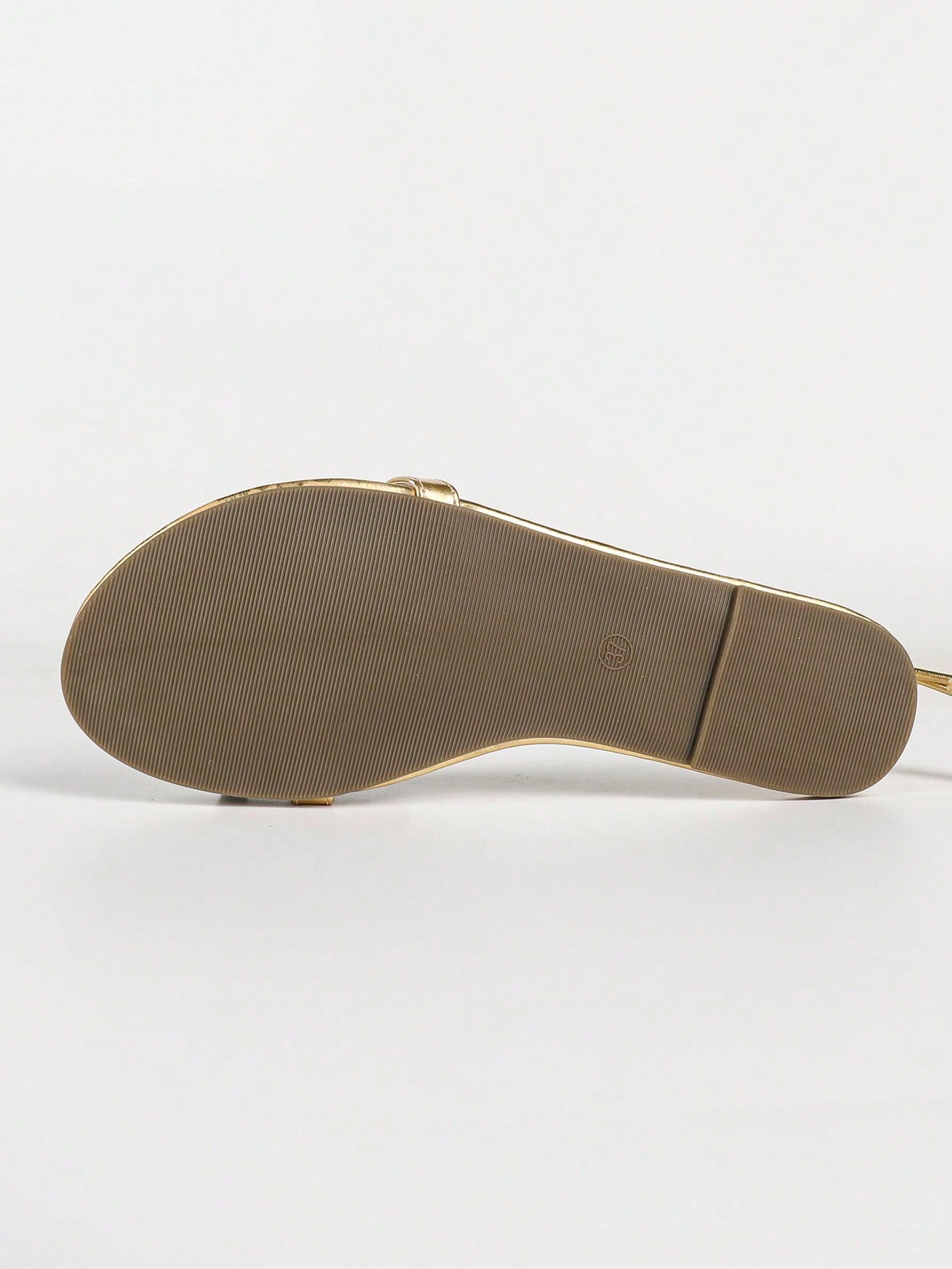 Women's gold flat sandals with metal accent detail, strappy lace-up design, and toe post thong style.