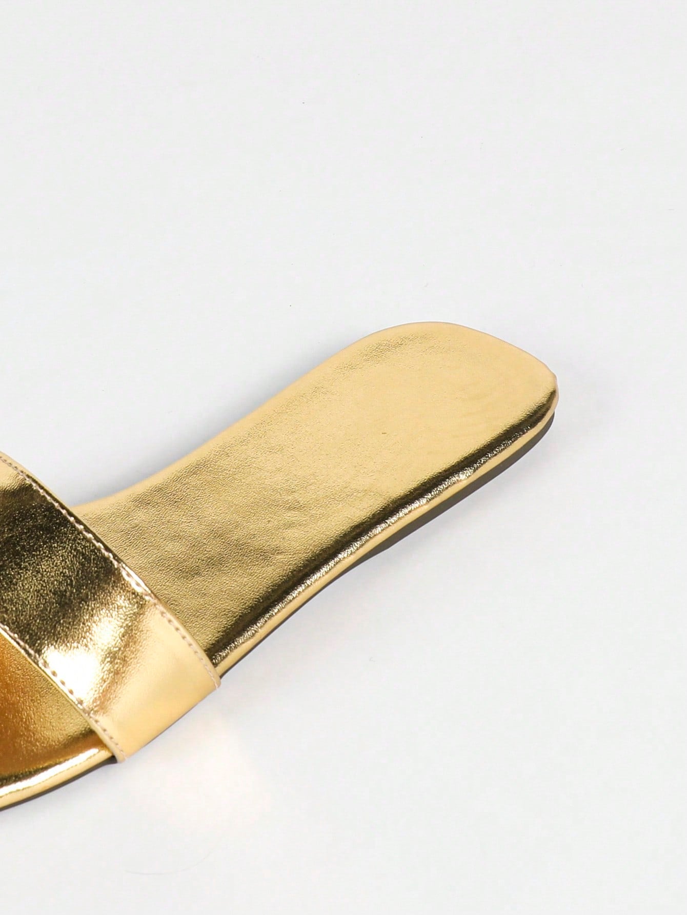 Women's gold flat sandals with metal accent detail, strappy lace-up design, and toe post thong style.