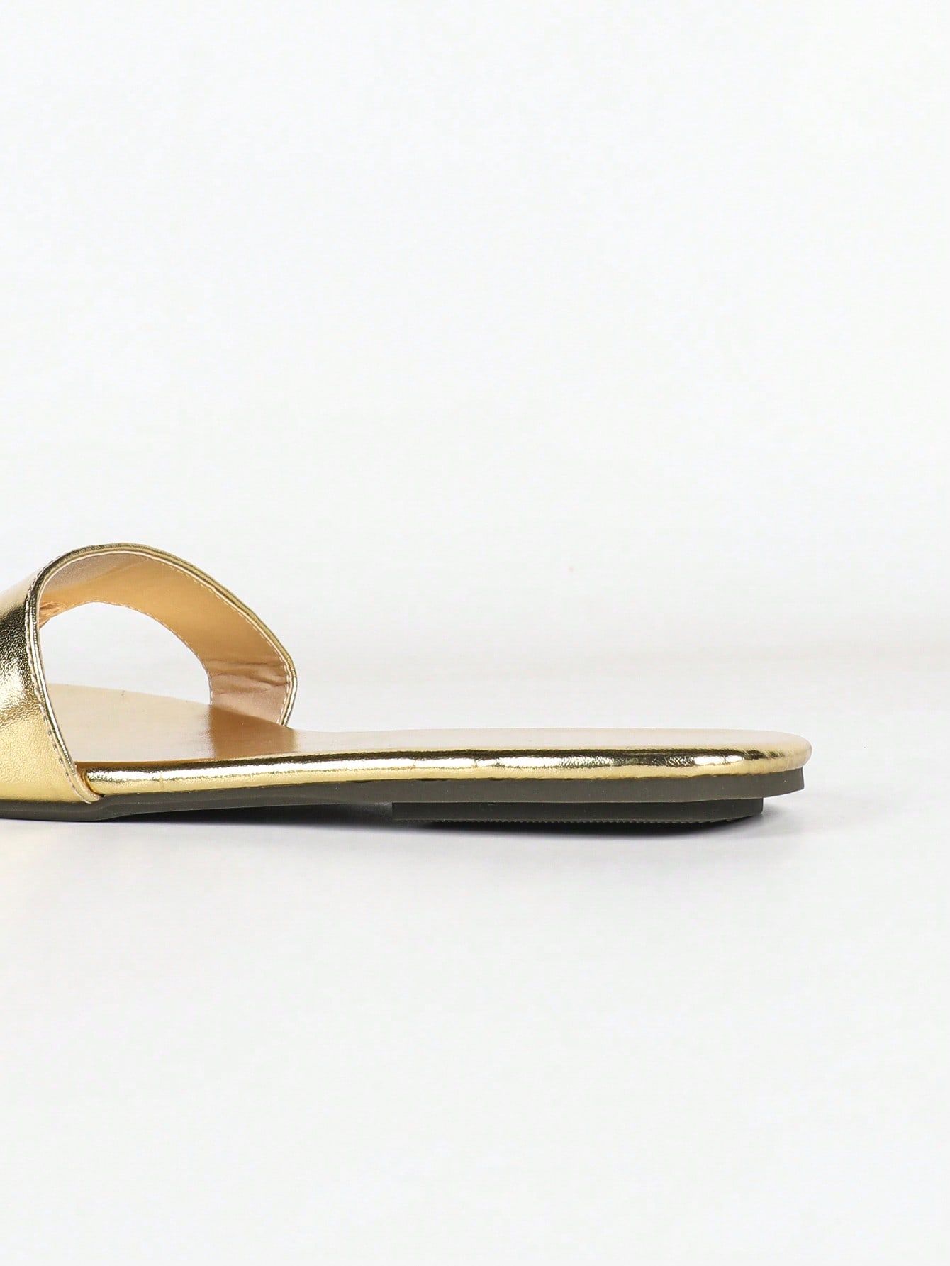 Women's gold flat sandals with metal accent detail, strappy lace-up design, and toe post thong style.