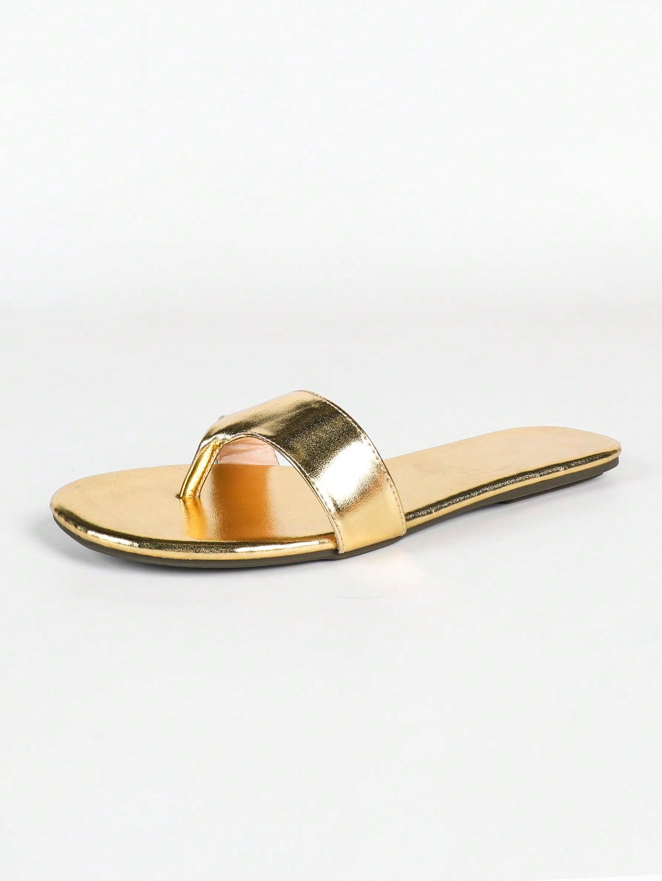 Women's gold flat sandals with metal accent detail, strappy lace-up design, and toe post thong style.