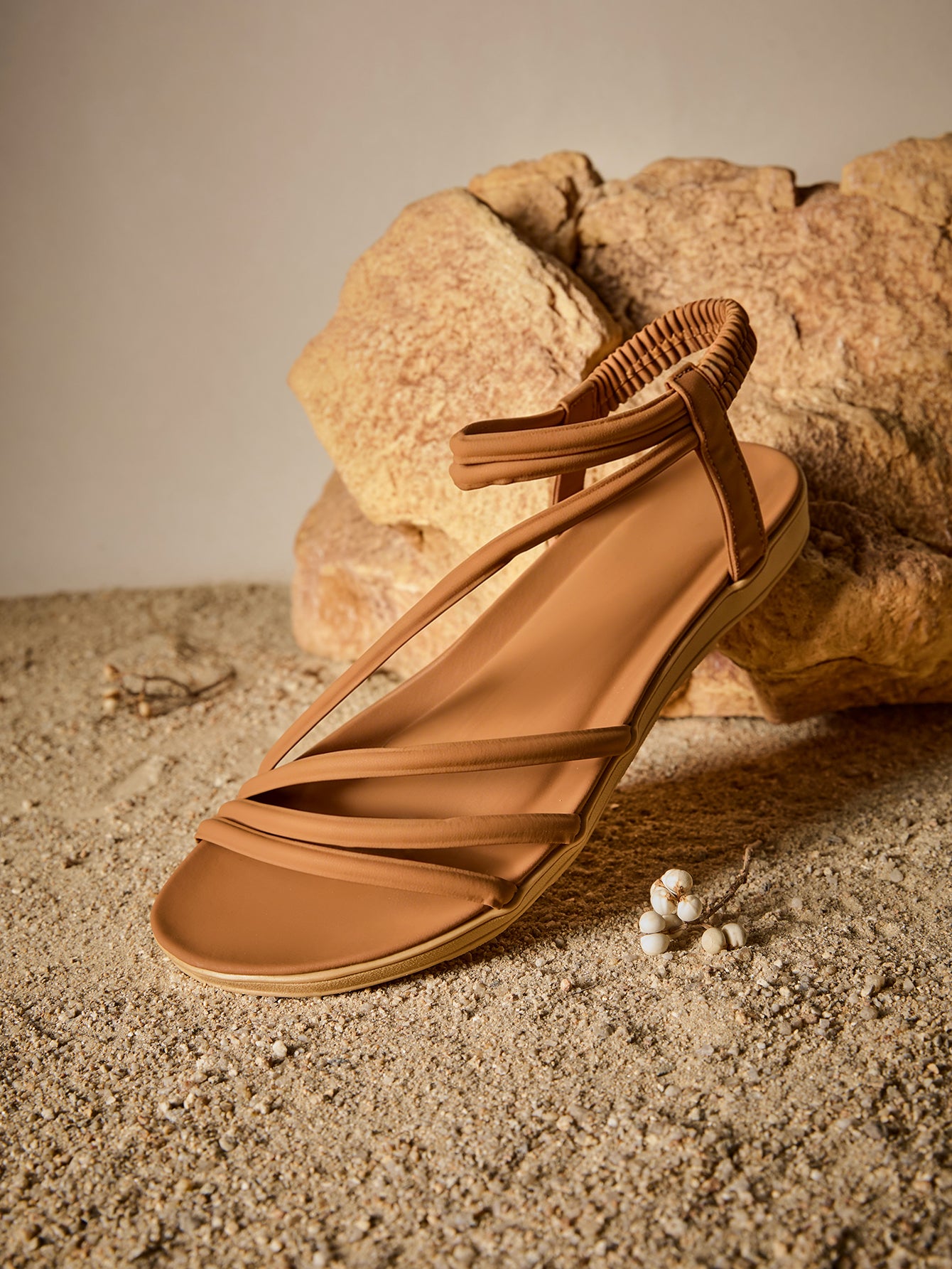 Brown women's strappy flat sandals with ruched details, animal pattern, and open-toe design.