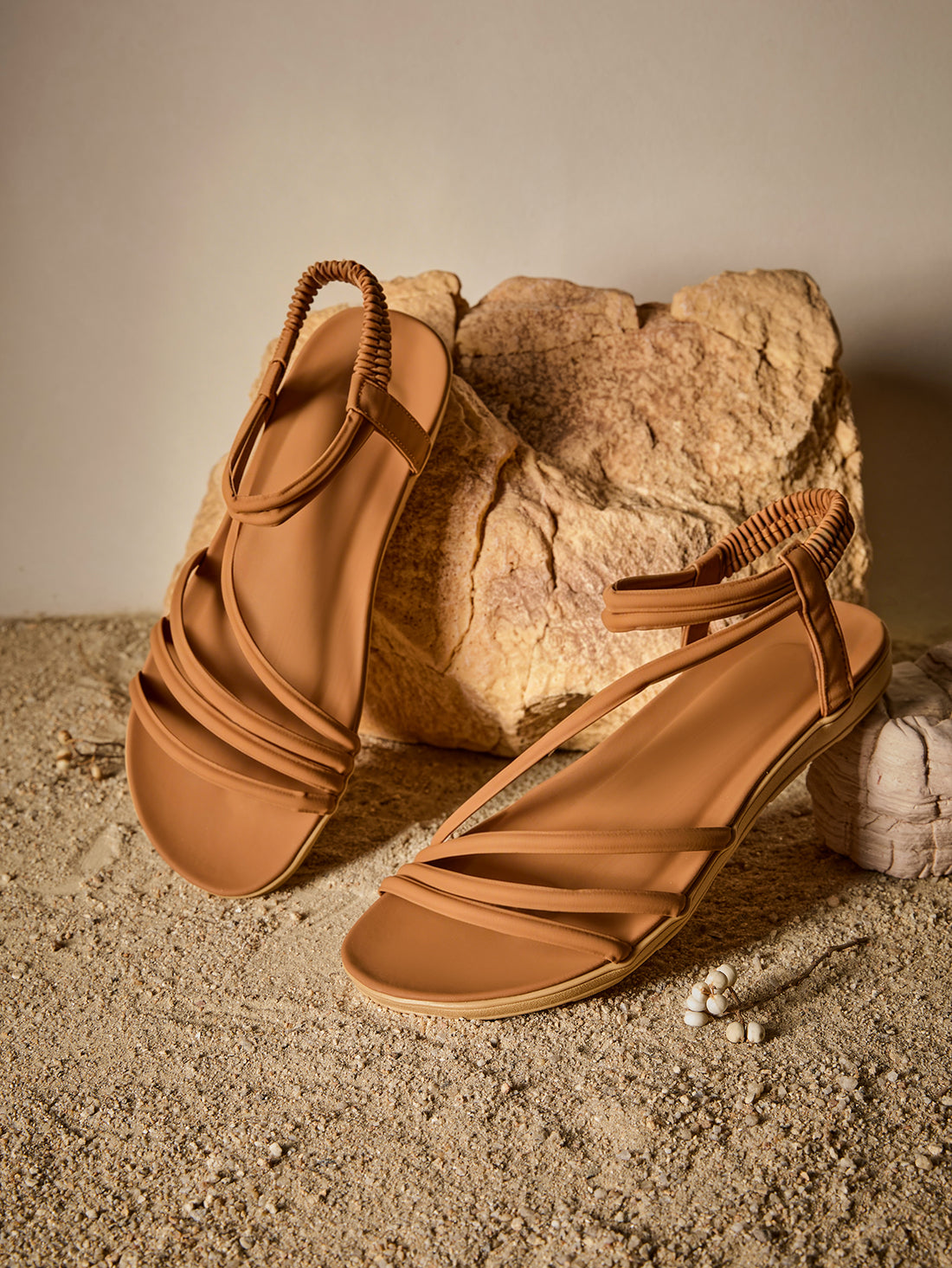 Brown women's strappy flat sandals with ruched details, animal pattern, and open-toe design.