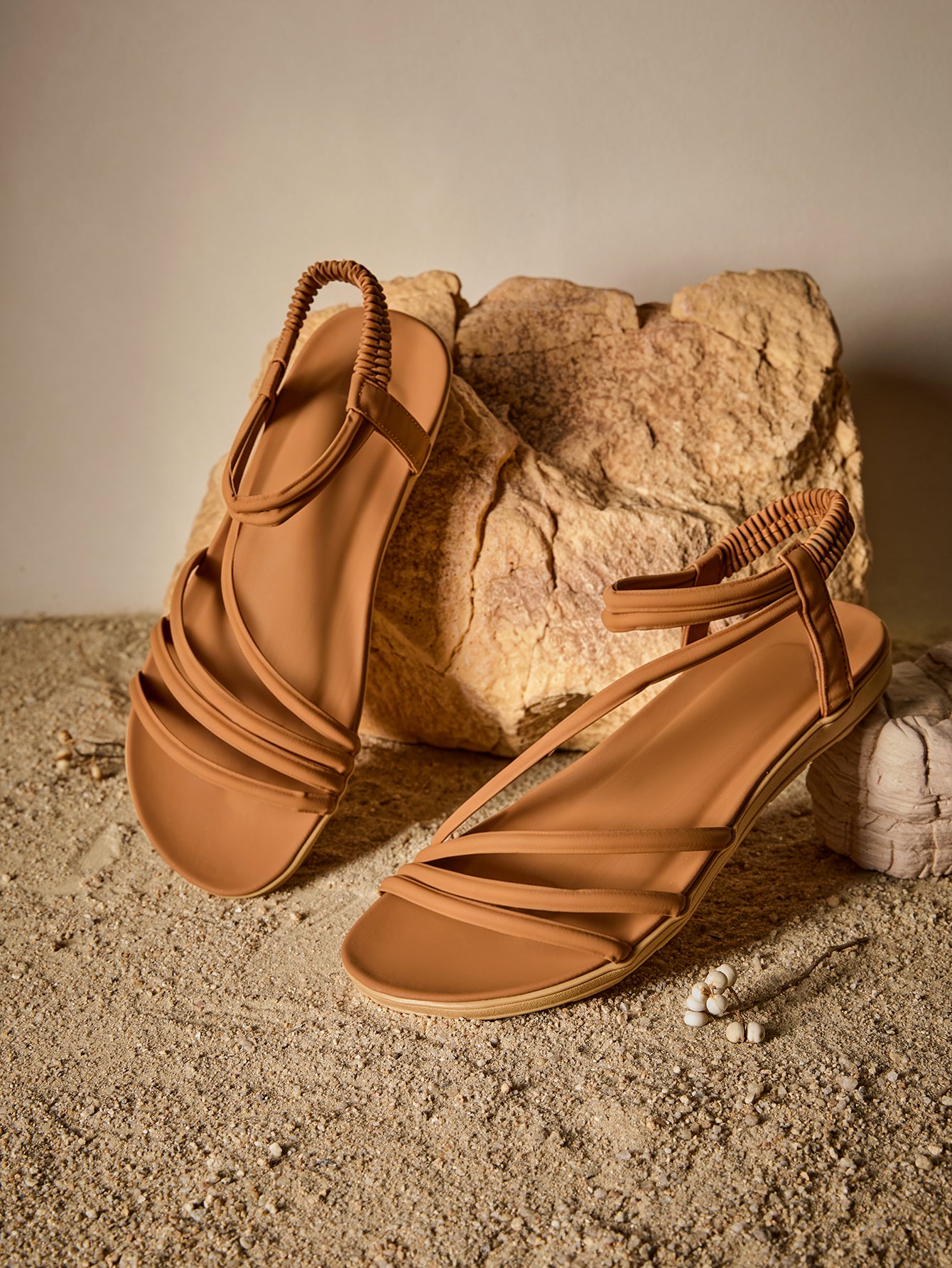 Brown women's strappy flat sandals with ruched details, animal pattern, and open-toe design.