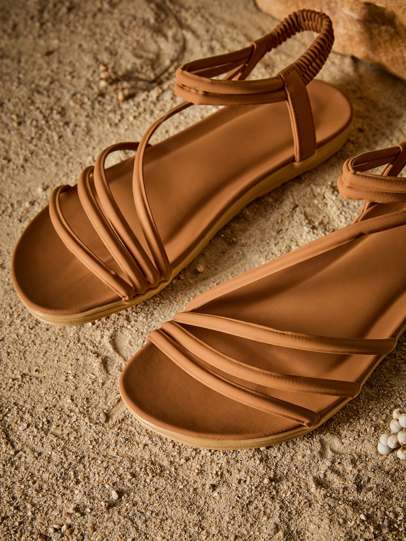 Brown women's strappy flat sandals with ruched details, animal pattern, and open-toe design.