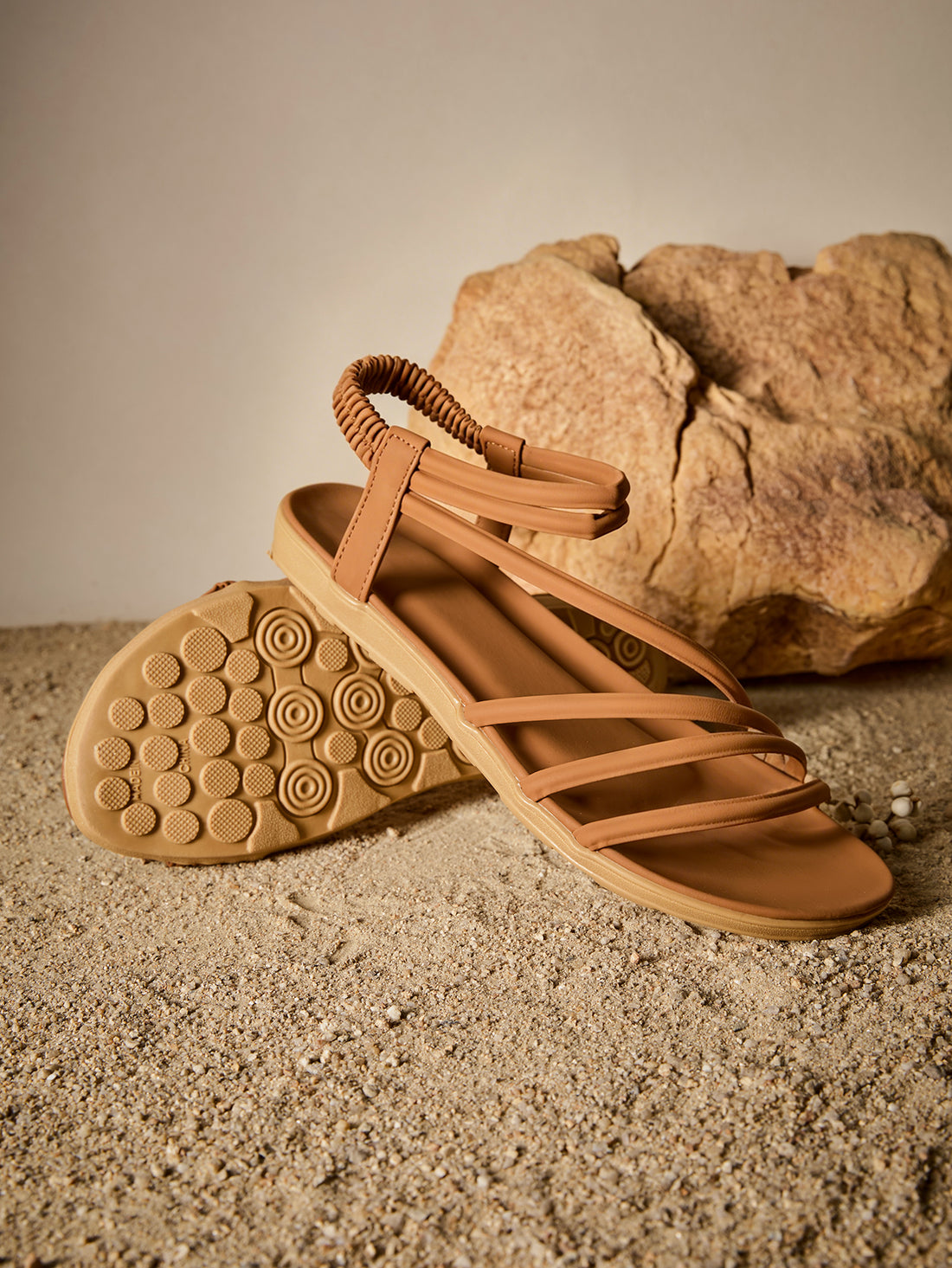 Brown women's strappy flat sandals with ruched details, animal pattern, and open-toe design.