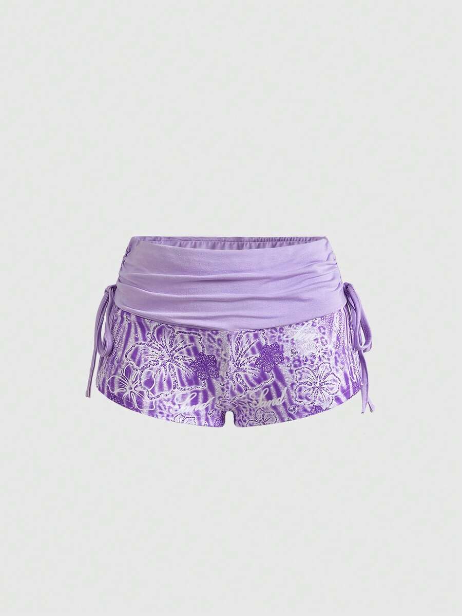 Women's low waist mini track shorts with elastic waistband, drawstring knot, ruched details, and plant pattern in a Y2K boho style