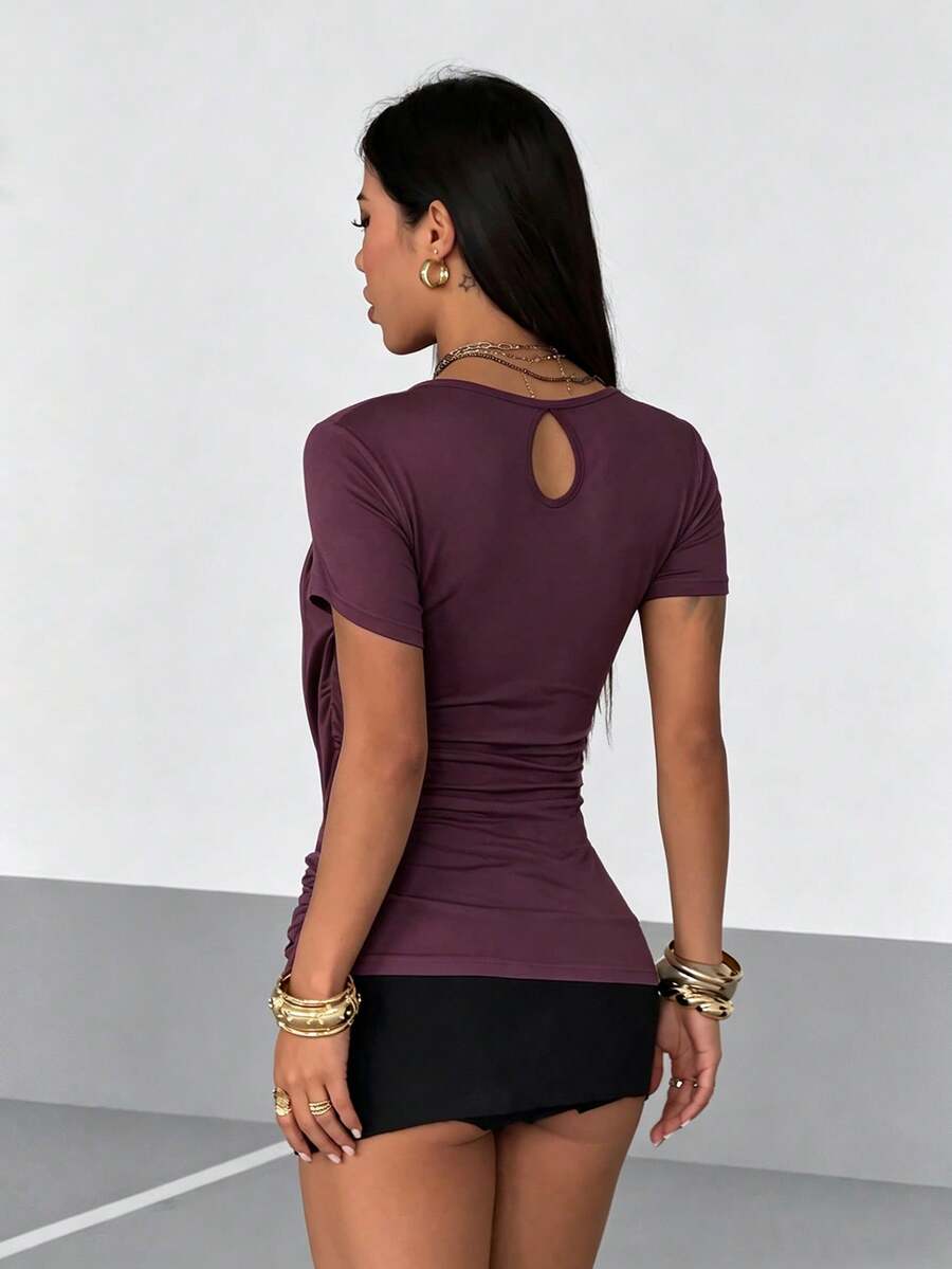 Women's slim fit short sleeve T-shirt with a low cut cowl neck, ruched details, and ruffle hem in a casual Y2K-inspired streetwear style.