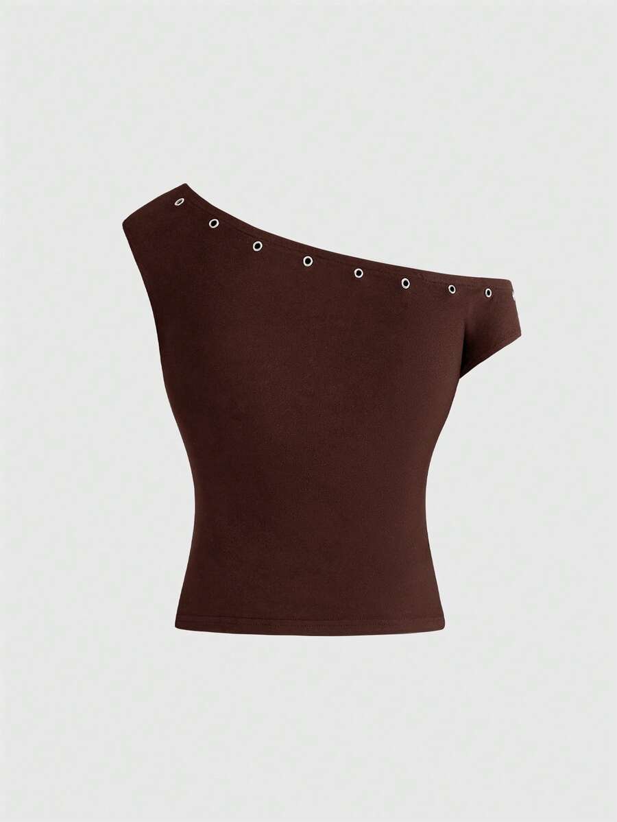 Women's two-piece outfit with an asymmetric neck studded grommet crop top and super low-rise mini shorts