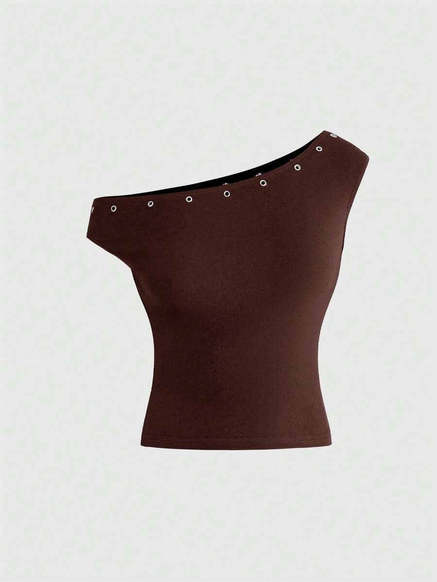 Women's two-piece outfit with an asymmetric neck studded grommet crop top and super low-rise mini shorts