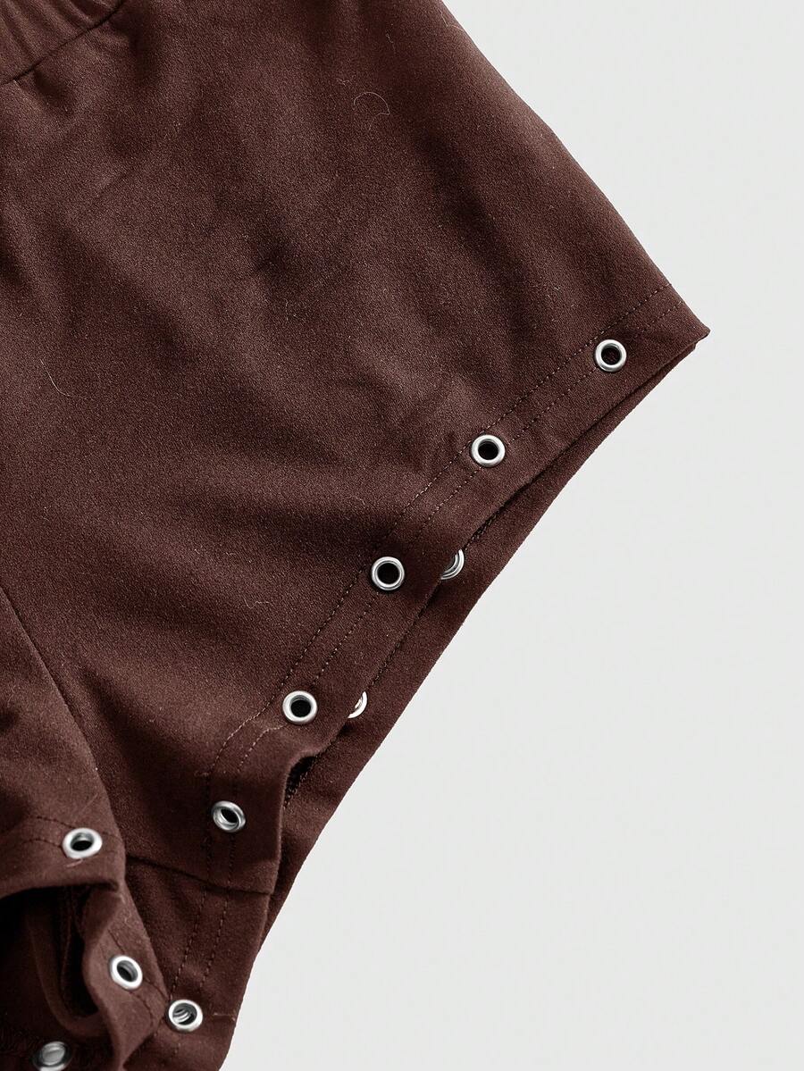 Women's two-piece outfit with an asymmetric neck studded grommet crop top and super low-rise mini shorts