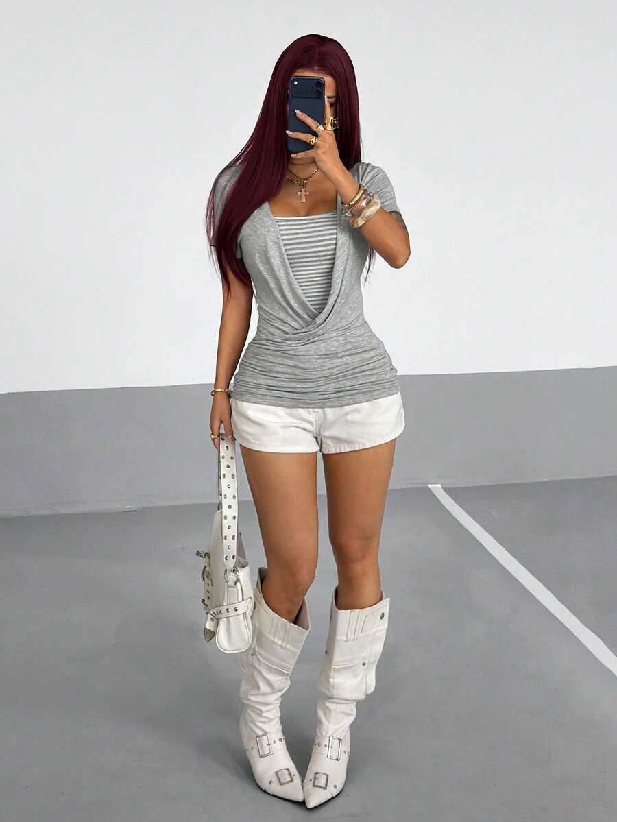 Women's slim fit short sleeve T-shirt with a low cut cowl neck, ruched details, and ruffle hem in a casual Y2K-inspired streetwear style.