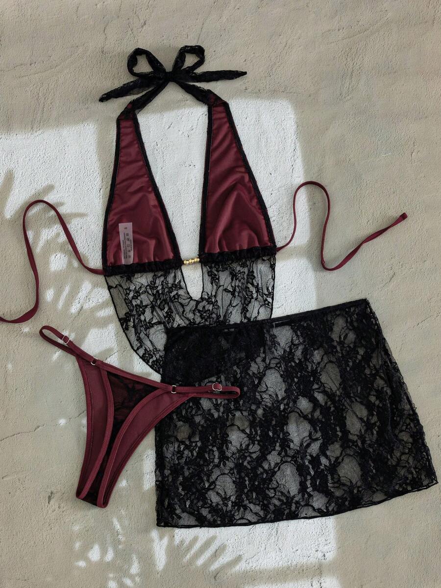 Women's black 3-piece bikini set with halter triangle top, backless design, ruched thong bottoms, and matching lace skirt for beach or vacation wear.