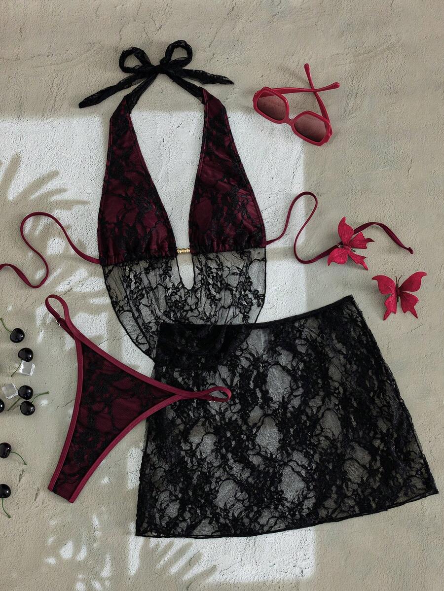 Women's black 3-piece bikini set with halter triangle top, backless design, ruched thong bottoms, and matching lace skirt for beach or vacation wear.