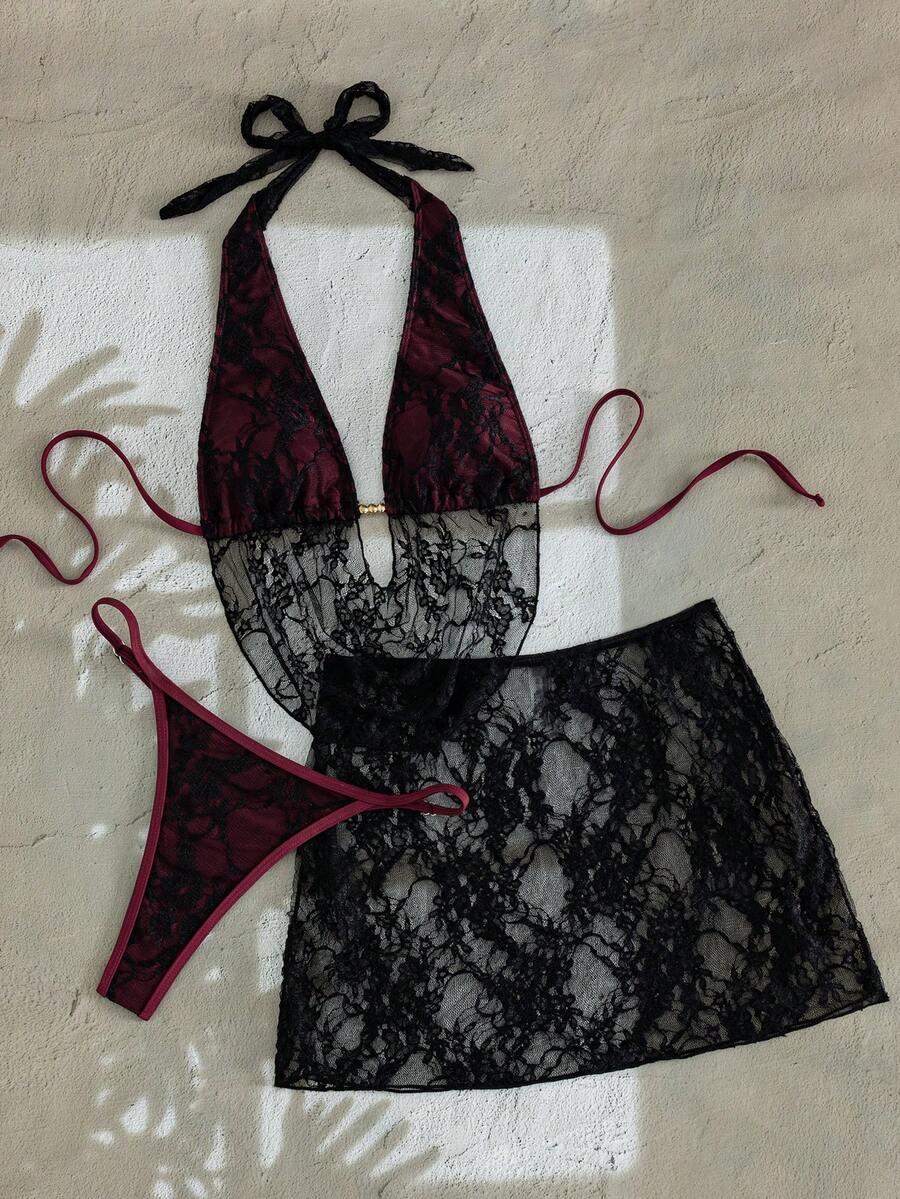 Women's black 3-piece bikini set with halter triangle top, backless design, ruched thong bottoms, and matching lace skirt for beach or vacation wear.