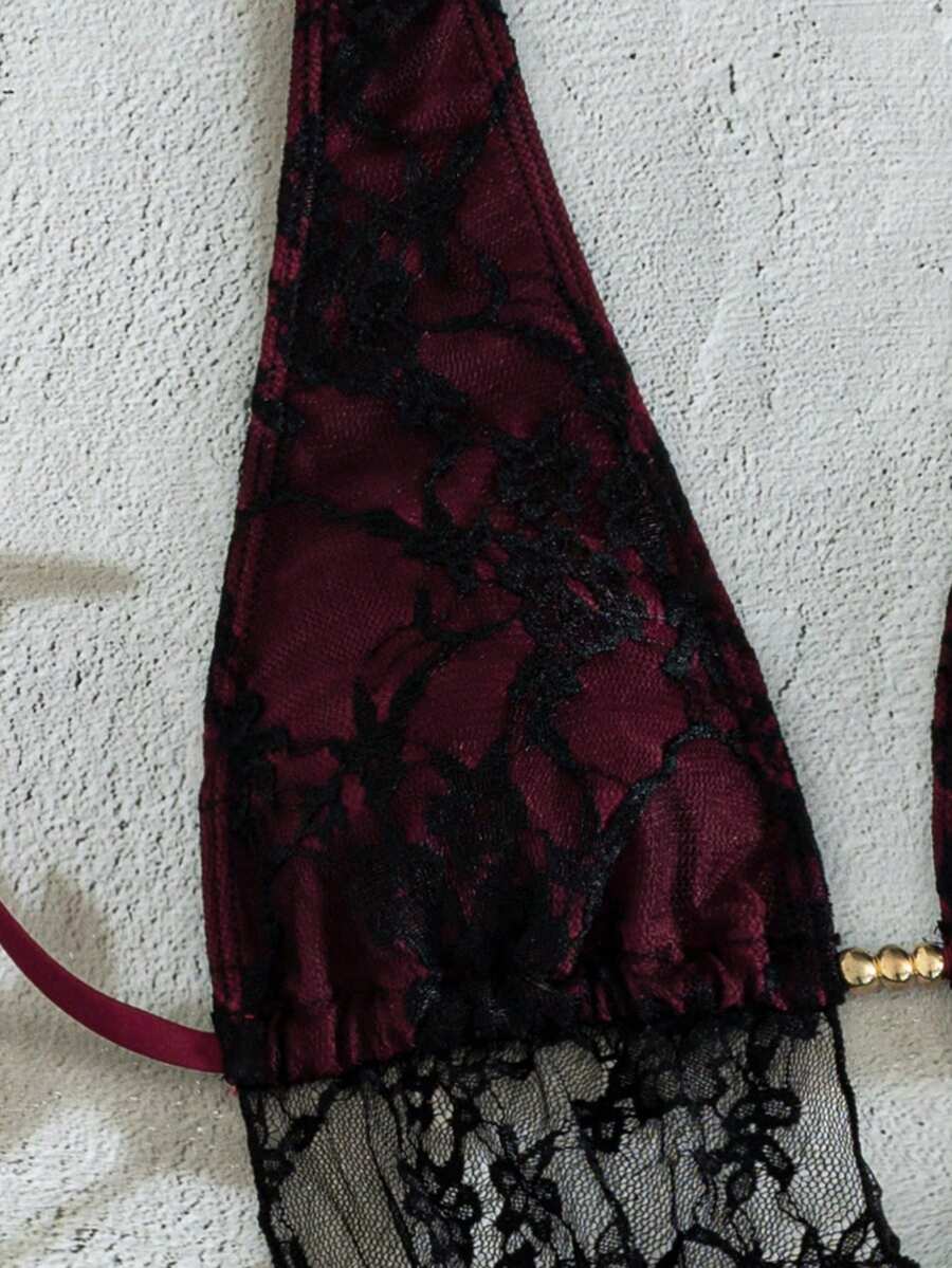 Women's black 3-piece bikini set with halter triangle top, backless design, ruched thong bottoms, and matching lace skirt for beach or vacation wear.