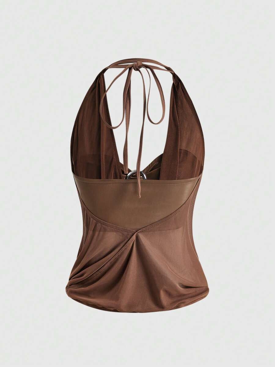 Women's Gyaru-style two-piece outfit with a draped halter crop top, backless tie detail, and mini bodycon shorts
