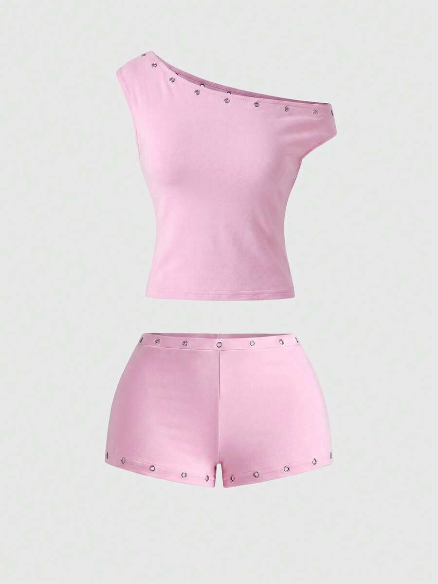 Women's two-piece outfit with an asymmetric neck studded grommet crop top and super low-rise mini shorts