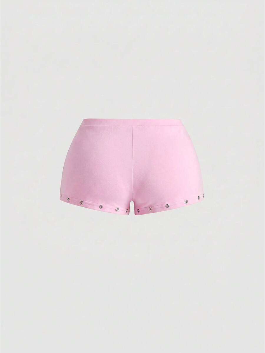 Women's two-piece outfit with an asymmetric neck studded grommet crop top and super low-rise mini shorts