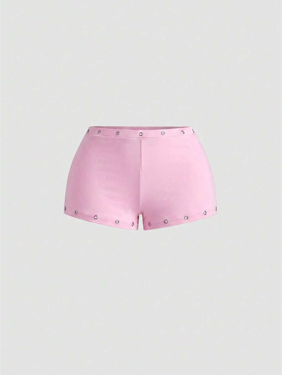 Women's two-piece outfit with an asymmetric neck studded grommet crop top and super low-rise mini shorts