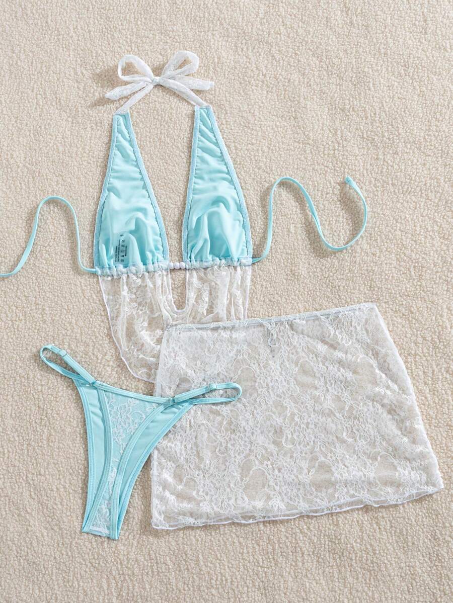 Women's black 3-piece bikini set with halter triangle top, backless design, ruched thong bottoms, and matching lace skirt for beach or vacation wear.