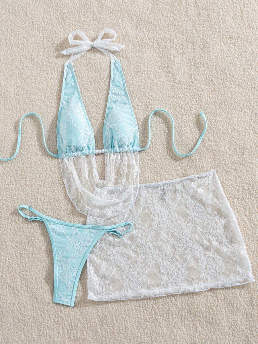 Women's black 3-piece bikini set with halter triangle top, backless design, ruched thong bottoms, and matching lace skirt for beach or vacation wear.
