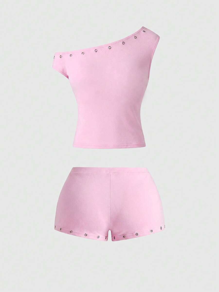 Women's two-piece outfit with an asymmetric neck studded grommet crop top and super low-rise mini shorts