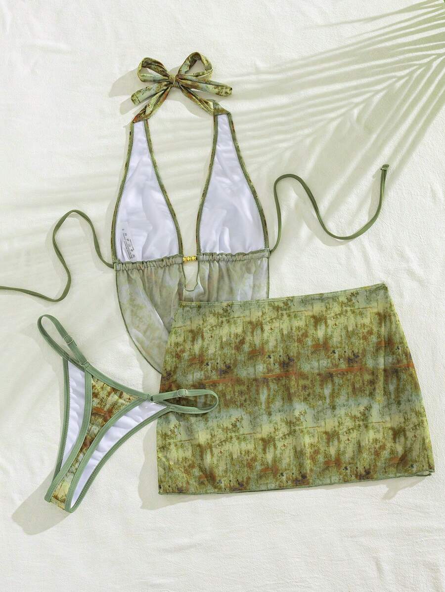 Women's black 3-piece bikini set with halter triangle top, backless design, ruched thong bottoms, and matching lace skirt for beach or vacation wear.