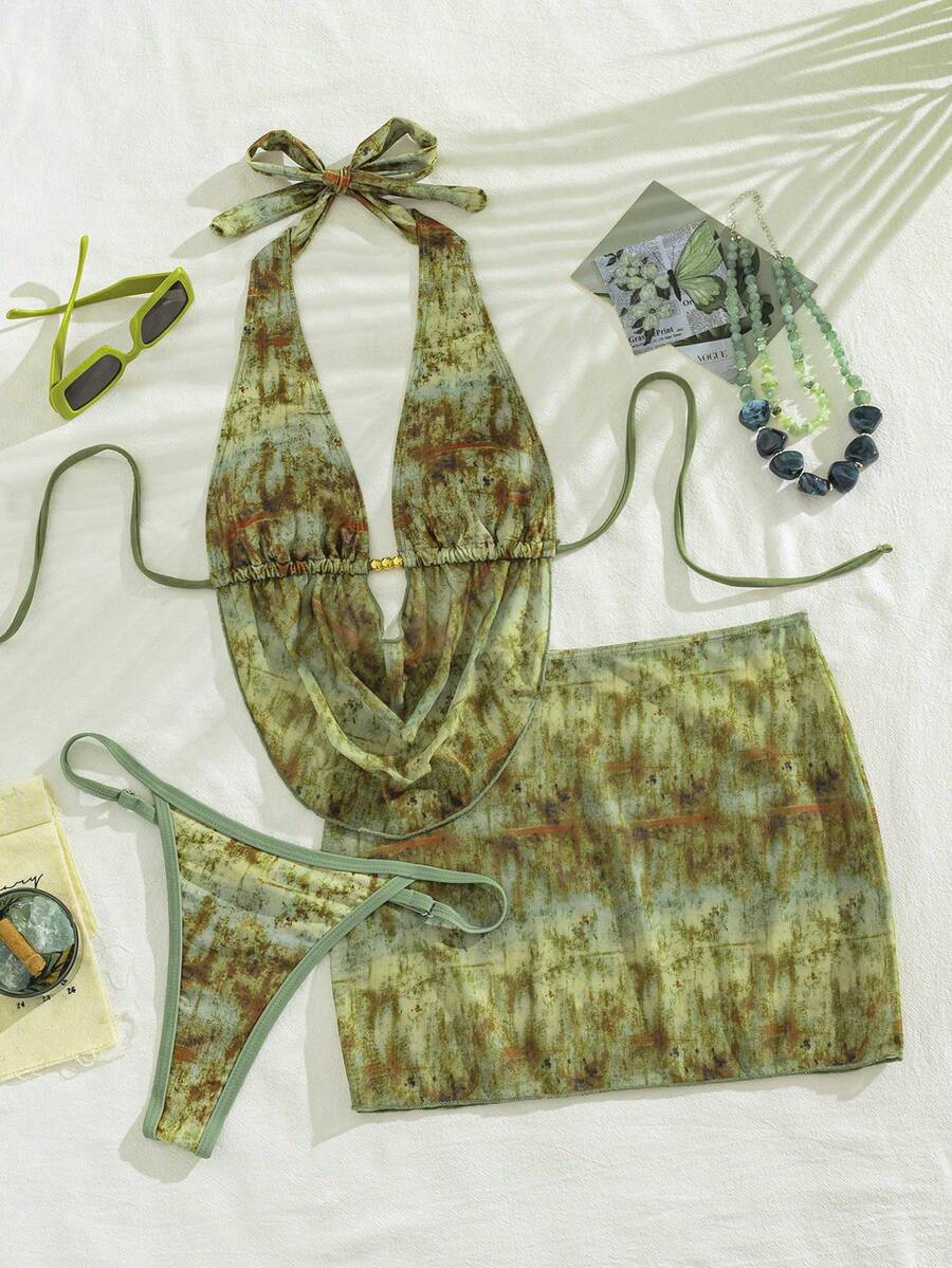 Women's black 3-piece bikini set with halter triangle top, backless design, ruched thong bottoms, and matching lace skirt for beach or vacation wear.
