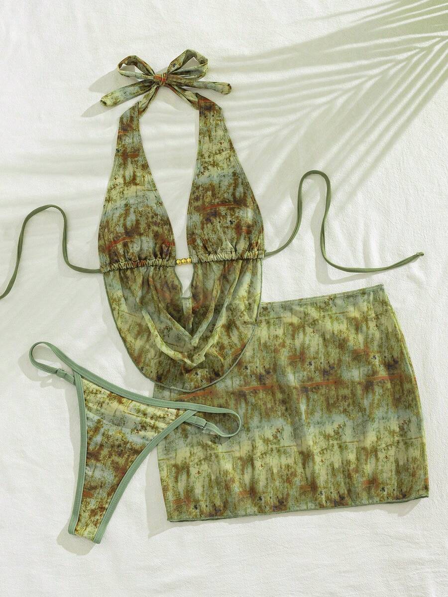 Women's black 3-piece bikini set with halter triangle top, backless design, ruched thong bottoms, and matching lace skirt for beach or vacation wear.