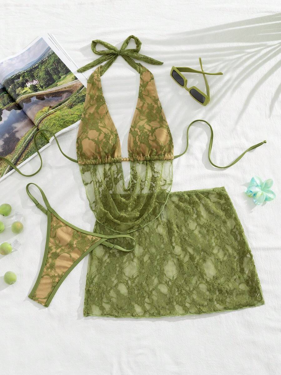 Women's black 3-piece bikini set with halter triangle top, backless design, ruched thong bottoms, and matching lace skirt for beach or vacation wear.