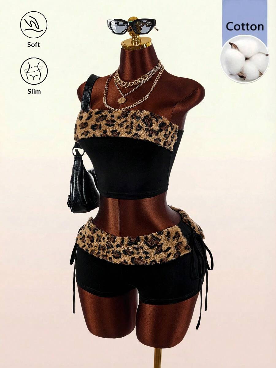 Women's black leopard print two-piece set with strapless bandeau crop top, knot and lace-up details, and matching mini shorts.