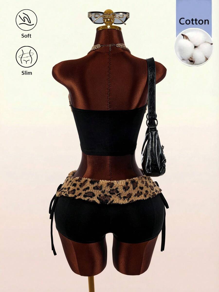 Women's black leopard print two-piece set with strapless bandeau crop top, knot and lace-up details, and matching mini shorts.