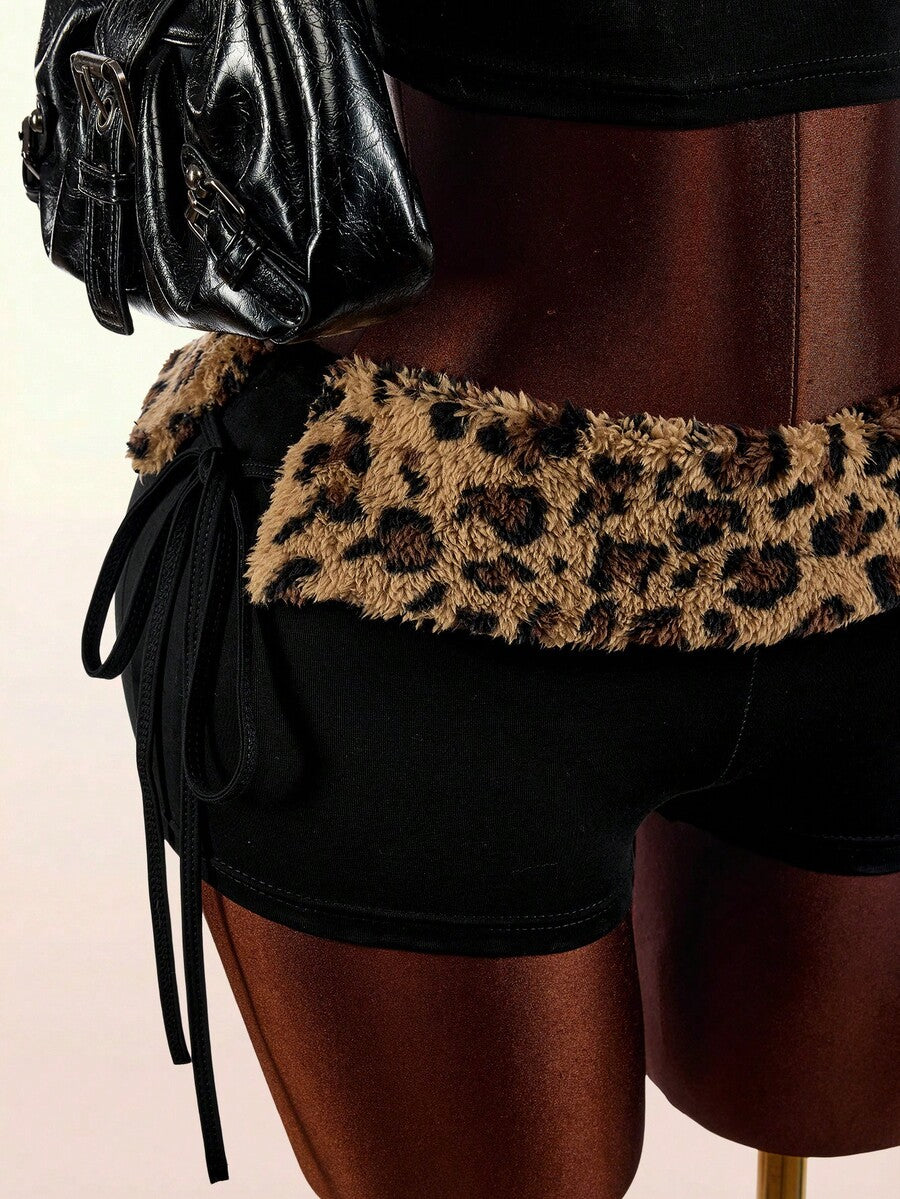 Women's black leopard print two-piece set with strapless bandeau crop top, knot and lace-up details, and matching mini shorts.