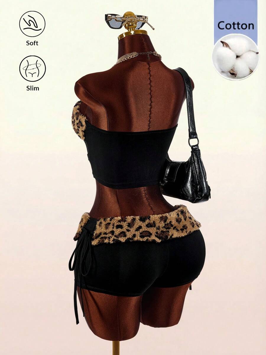 Women's black leopard print two-piece set with strapless bandeau crop top, knot and lace-up details, and matching mini shorts.