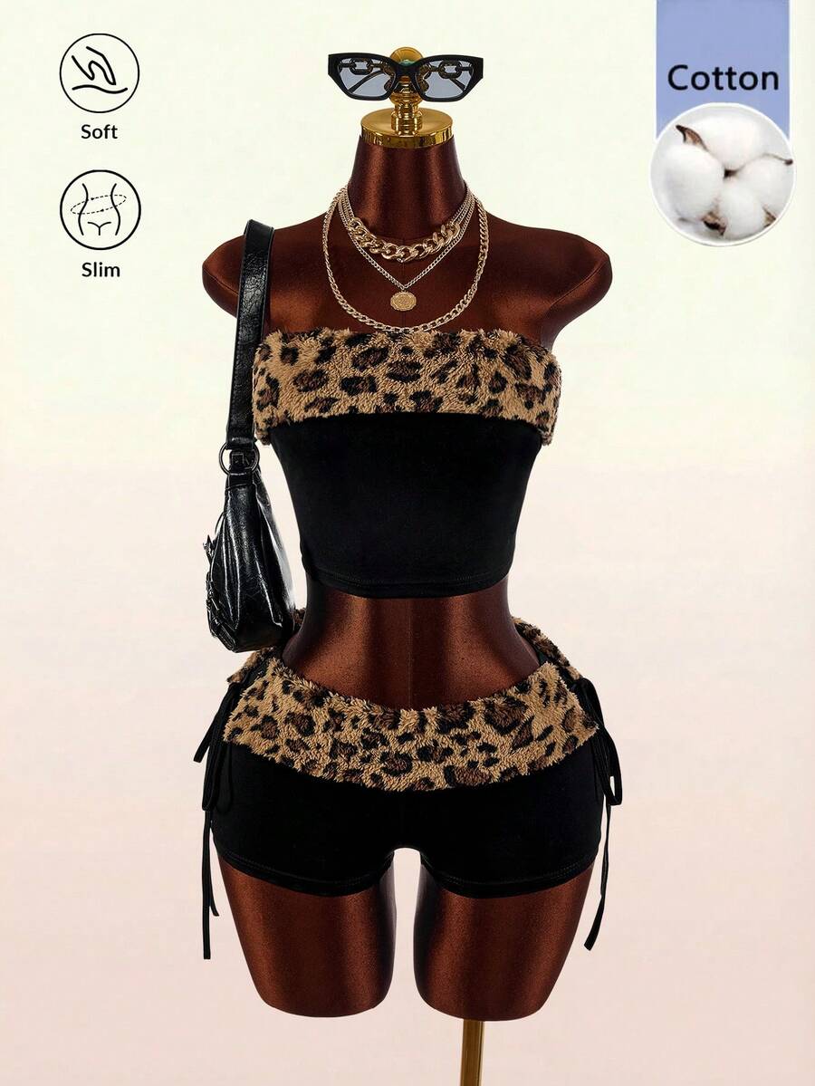 Women's black leopard print two-piece set with strapless bandeau crop top, knot and lace-up details, and matching mini shorts.