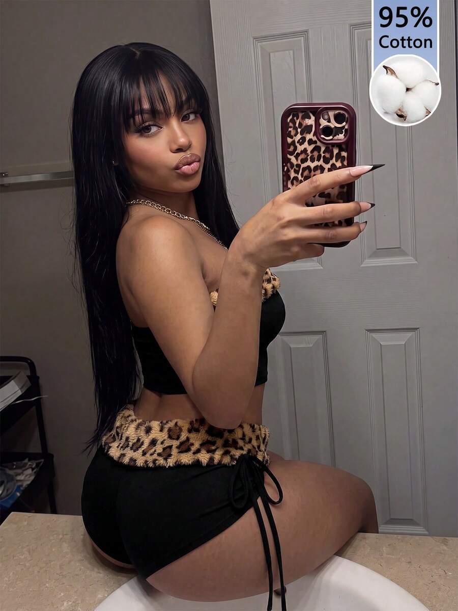 Women's black leopard print two-piece set with strapless bandeau crop top, knot and lace-up details, and matching mini shorts.