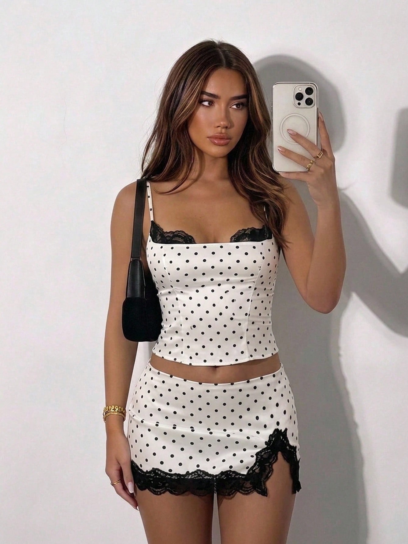 Women's black and white polka dot 2-piece set with contrast lace camisole, spaghetti straps, and matching side slit mini skirt